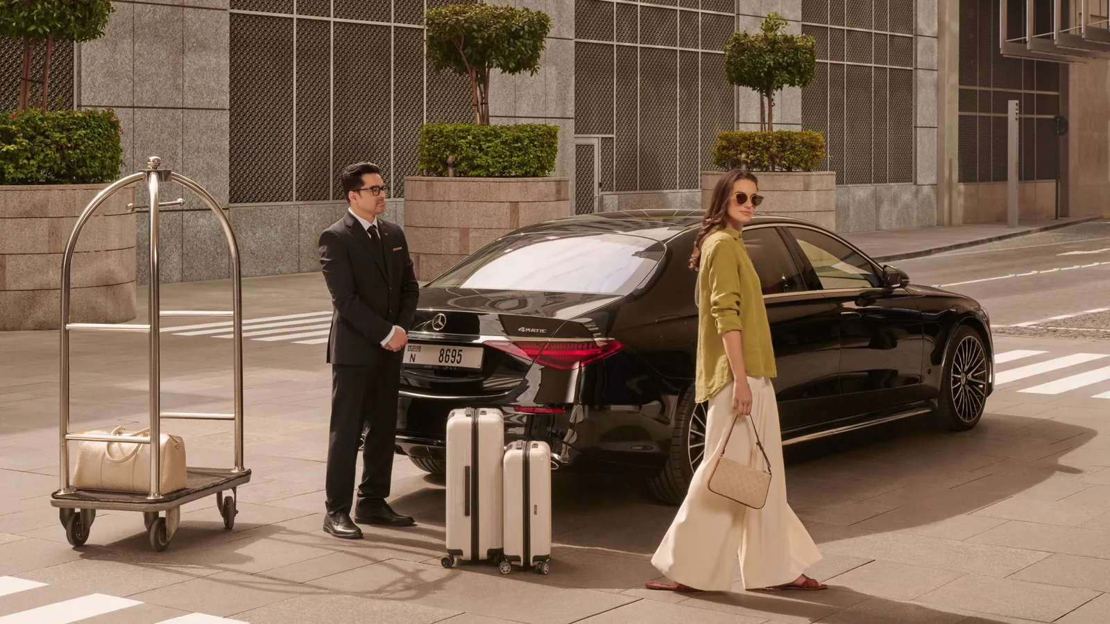 Chauffeur with luggage trolley meeting a guest at a hotel