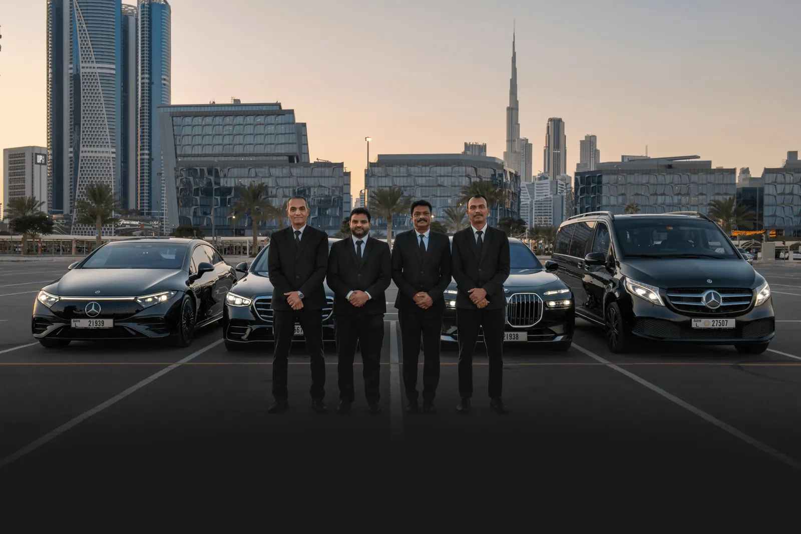 Tour Transfer chauffeurs with the luxury fleet in front of the Dubai skyline