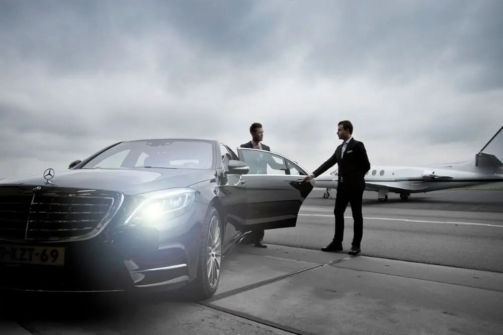 Chauffeur and Mercedes meeting a private jet on the apron
